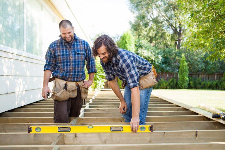 Construction Worker Checking Level Of Wood With Spirit Level While