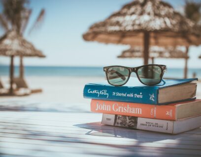 A pile of books ready for reading on the beach